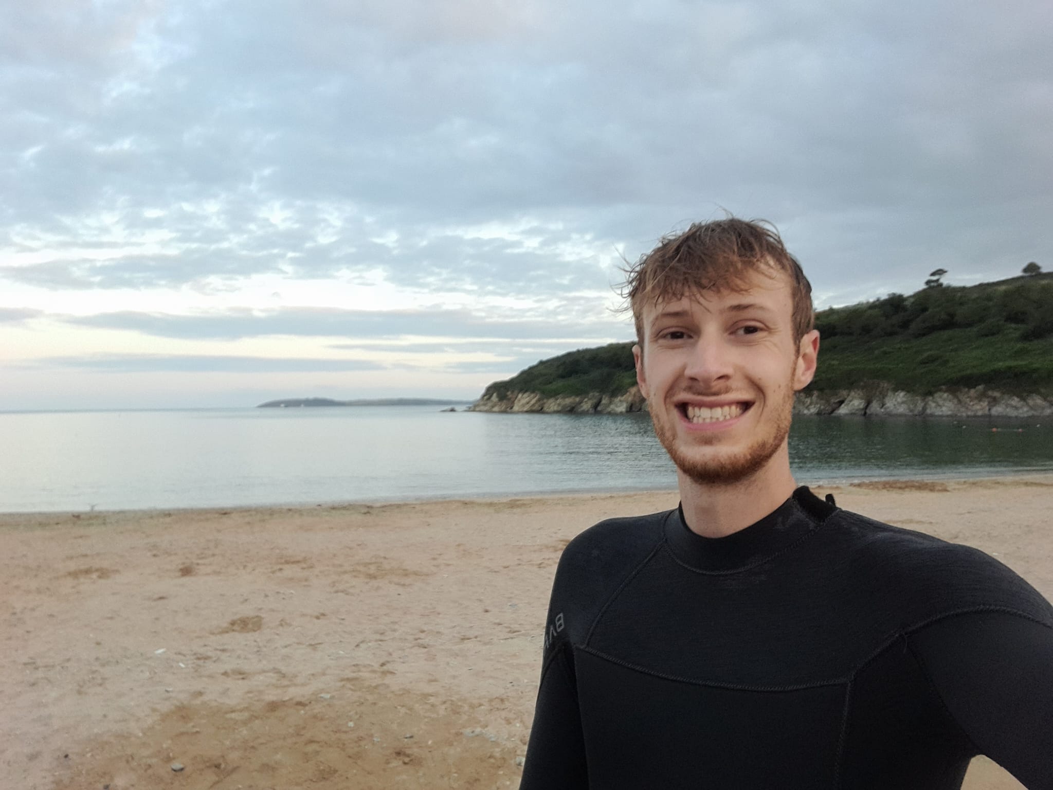 A photo of Thomas on the beach with the sea in the background